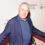 man in blue blazer posing at a film festival step-and-repeat