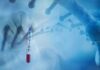 Pandemic Billing Under Fire as Michigan Lab Settles Medicare Case Gloved hand holding a COVID-19 test tube beside a stylized DNA helix