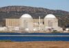 Missiles Strike Near Iran’s Only Nuclear Plant Nuclear power plant with domed structures beside a water body and mountains in the background
