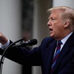 man speaking at a podium and pointing