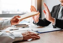 Businessperson refusing an envelope at a desk