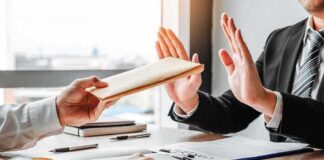 Businessperson refusing an envelope at a desk