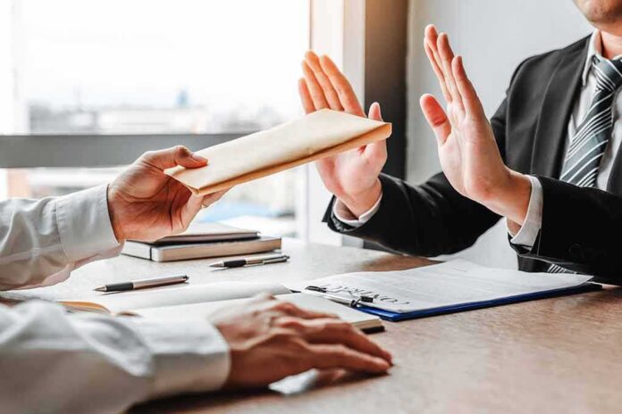 Businessperson refusing an envelope at a desk