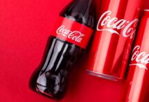 Coca-Cola Faces New Backlash Over Personalized Cans Coca-Cola bottle and cans on a red background