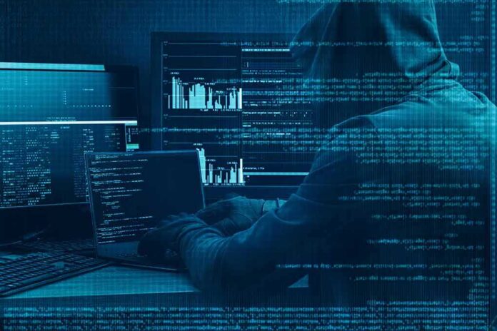 shutterstock_578912143 Hooded person at multiple computer screens with code and charts