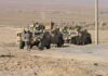 U.S. Pullback Changes Iraq Strategy Soldiers near armored vehicles in a desert