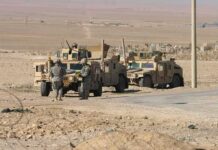 U.S. Pullback Changes Iraq Strategy Soldiers near armored vehicles in a desert
