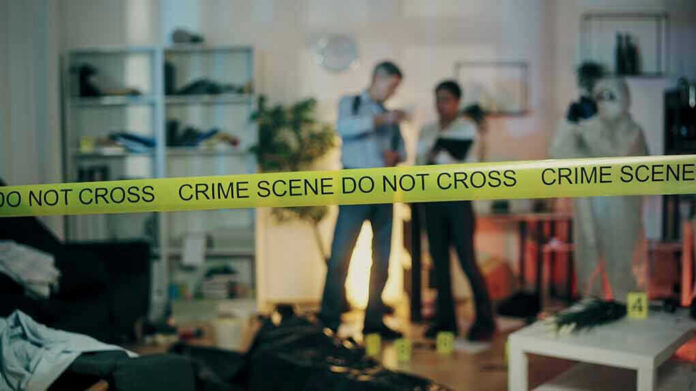 2386626691-1 Crime scene with tape and investigators examining evidence.