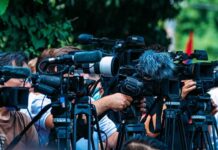 Repeats “Islam Is Peace” Message TV news cameras crowding together at an outdoor event