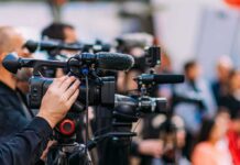 Dallas Mayor Defends Party Switch Video cameras on tripods at a media event