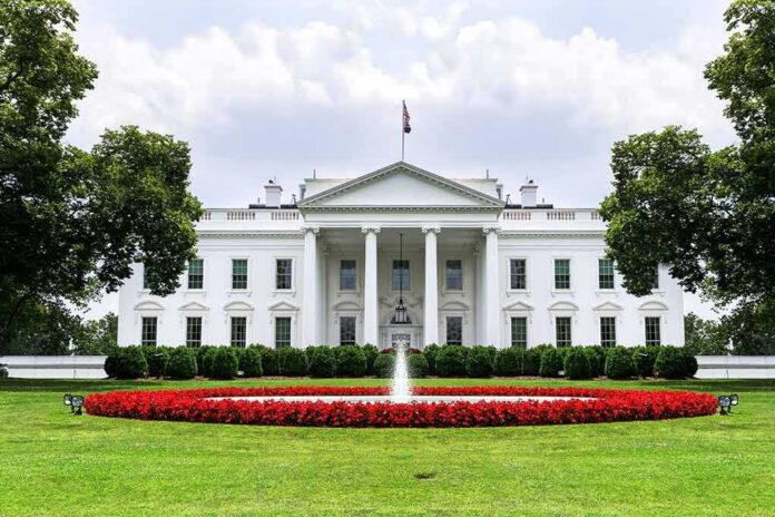 shutterstock_1016809915 The White House with fountain and red flower bed