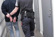 LA Homeless Funds Scandal Sparks New Scrutiny Security officer escorts handcuffed person down hallway