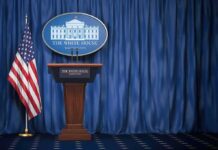 WHO Pushes Back on Trump’s Childhood Vaccine Shake-Up White House press briefing podium with U.S. flag and blue curtain