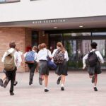 Nepal Principal Saves 900 Students From Flash Flood Students in uniforms running toward a school entrance