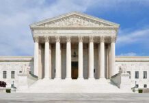 Mail Voting Fight Heads Back to Court Front view of the Supreme Court building with large columns and steps under a blue sky