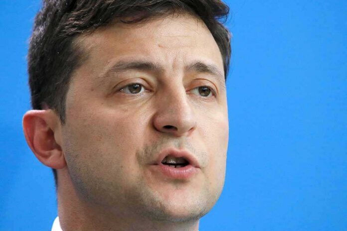 Volodymyr Zelensky speaking in a close-up portrait against a blue background