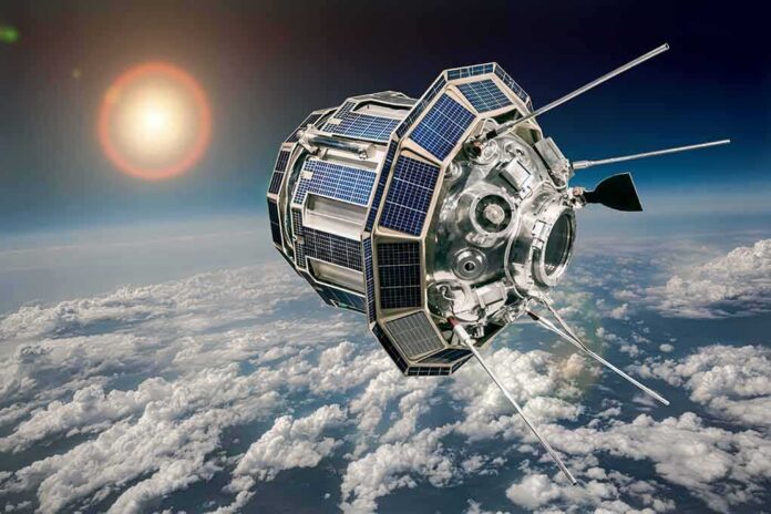 shutterstock_1493150903 Satellite with solar panels orbiting above Earth’s clouds