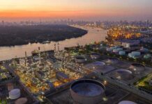 Ukraine Strikes Deep Into Russia Industrial oil refinery complex beside a river at dusk