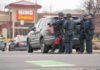Austin Shooting Under Investigation Police officers gather beside a patrol SUV at a taped-off scene