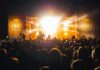 Crowd at a nighttime concert with bright stage lights