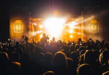 Crowd at a nighttime concert with bright stage lights