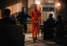 Former Titans Scout Gets Two Consecutive Life Sentences Defendant in orange jumpsuit escorted by officer in courtroom