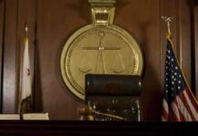 Patriotism Debate Erupts Over Comment A judges bench in a courtroom with a gavel and flags