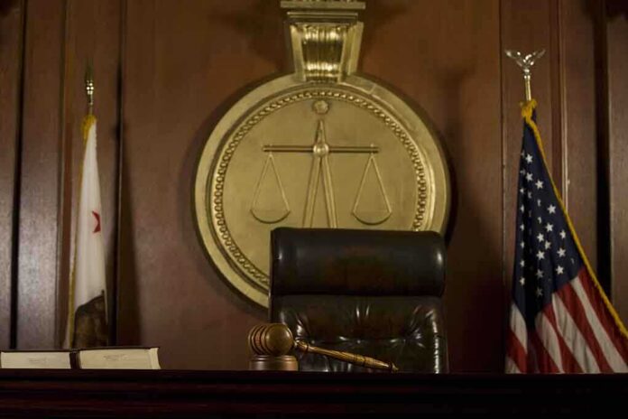 shutterstock_207066865 A judges bench in a courtroom with a gavel and flags