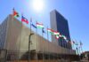 United Nations headquarters with member flags under bright sun