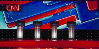 Debate stage with four podiums and colorful star backdrop