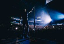 Billionaire Blocks Rapper, Tour Implodes Singer on stage facing a large concert crowd