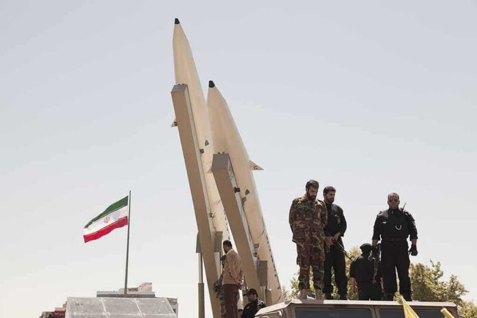 Soldiers stand beside large missiles at an outdoor display