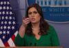 woman speaking at a press briefing podium