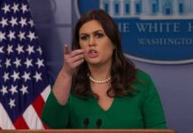 woman speaking at a press briefing podium