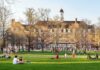 Viral Clip Fallout: College Exit Shocks Campus Students relaxing on a campus quad in front of a brick academic building