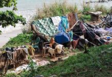 Displaced Palestinians Face Long Road Back to Gaza makeshift shelter near a beach with tarps and clothes drying