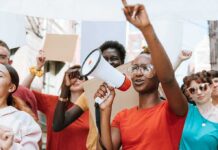 Viral Piker Clip Raises Questions About Activist Power Protester with megaphone leading a crowd