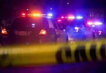 Hour-Long Macy’s Standoff Ends With a Fall Police cars with flashing lights behind yellow caution tape at night