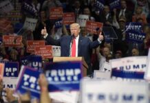 Donald Trump speaks at a rally, giving two thumbs up