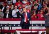 Rock Star Calls Himself a “Radical” at Trump Rally Donald Trump points from a rally stage; Rudi Koertzen and Bear Pascoe are in the crowd