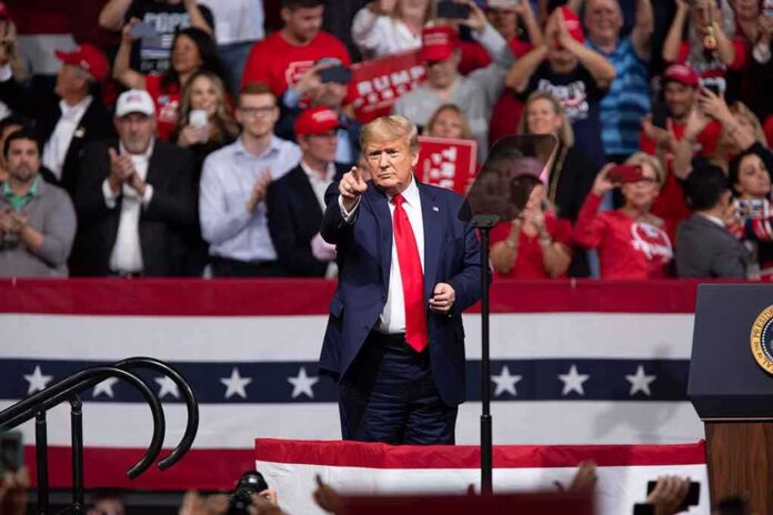shutterstock_1651529632-2 Donald Trump points from a rally stage; Rudi Koertzen and Bear Pascoe are in the crowd
