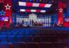 TV Debate Sparks Military Draft Fears Debate stage with red and blue lighting and empty audience seats