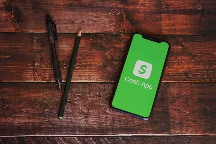 shutterstock_1739104436 Smartphone displaying Cash App on a wooden desk