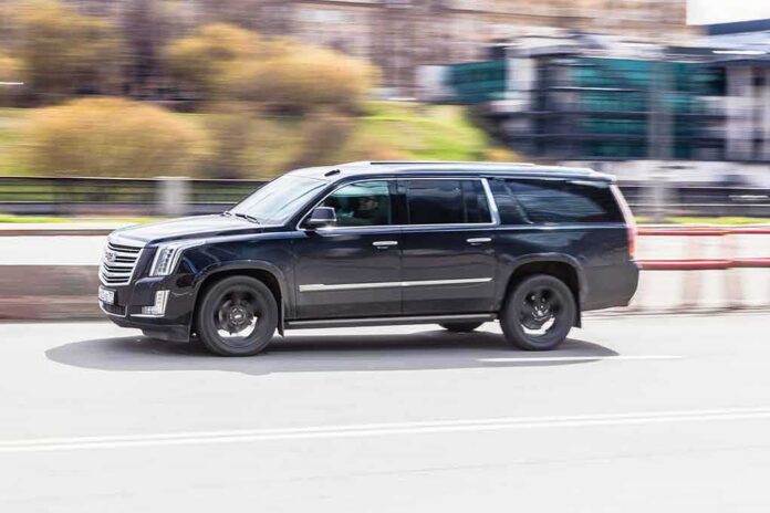 shutterstock_1972770389 Black SUV driving on city street