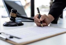 Canada Plans Major Assisted-Dying Law Change Hand signing legal document beside gavel and laptop
