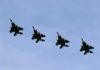 Iran Strikes Shake Global Markets Four fighter jets flying in formation against a clear sky