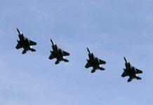 Four fighter jets flying in formation against a clear sky