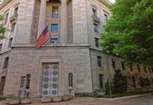 Citizenship Case Faces High Legal Bar Stone government building with American flag at entrance