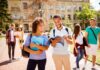 College students walking on campus with books and backpacks