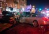 two cars collide on a city street at night